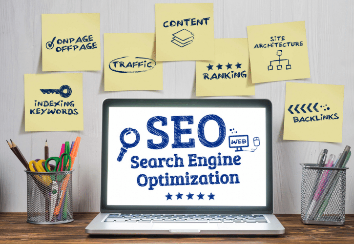 SEOの概念を示す付箋とノートパソコン。オンページ、オフページ、コンテンツ、トラフィック、ランキング、サイトアーキテクチャ、インデックス作成キーワード、バックリンク。