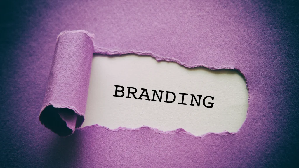 破れた紫色の紙の穴から見える「BRANDING」の文字