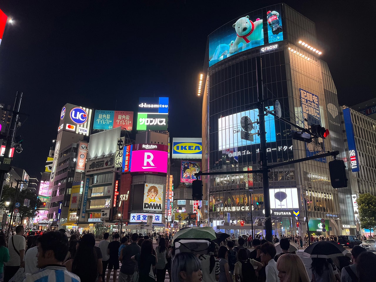渋谷スクランブル交差点の夜景、多数のブランドロゴが光る